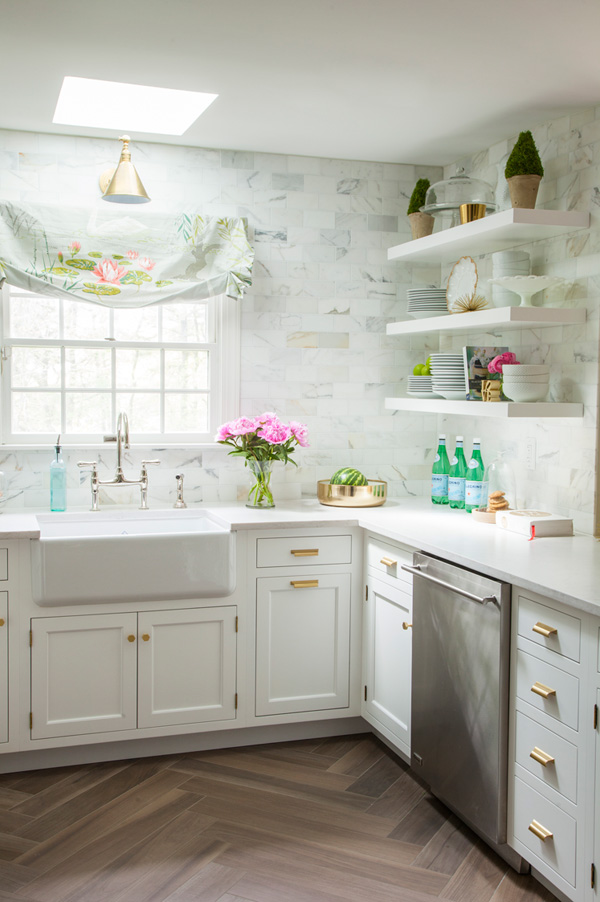 The walls are clad with marble subway tiles, there are white cabinets and floating shelves for comfortable and airy storage The walls are clad with marble subway tiles, there are white cabinets and floating shelves for comfortable and airy storage