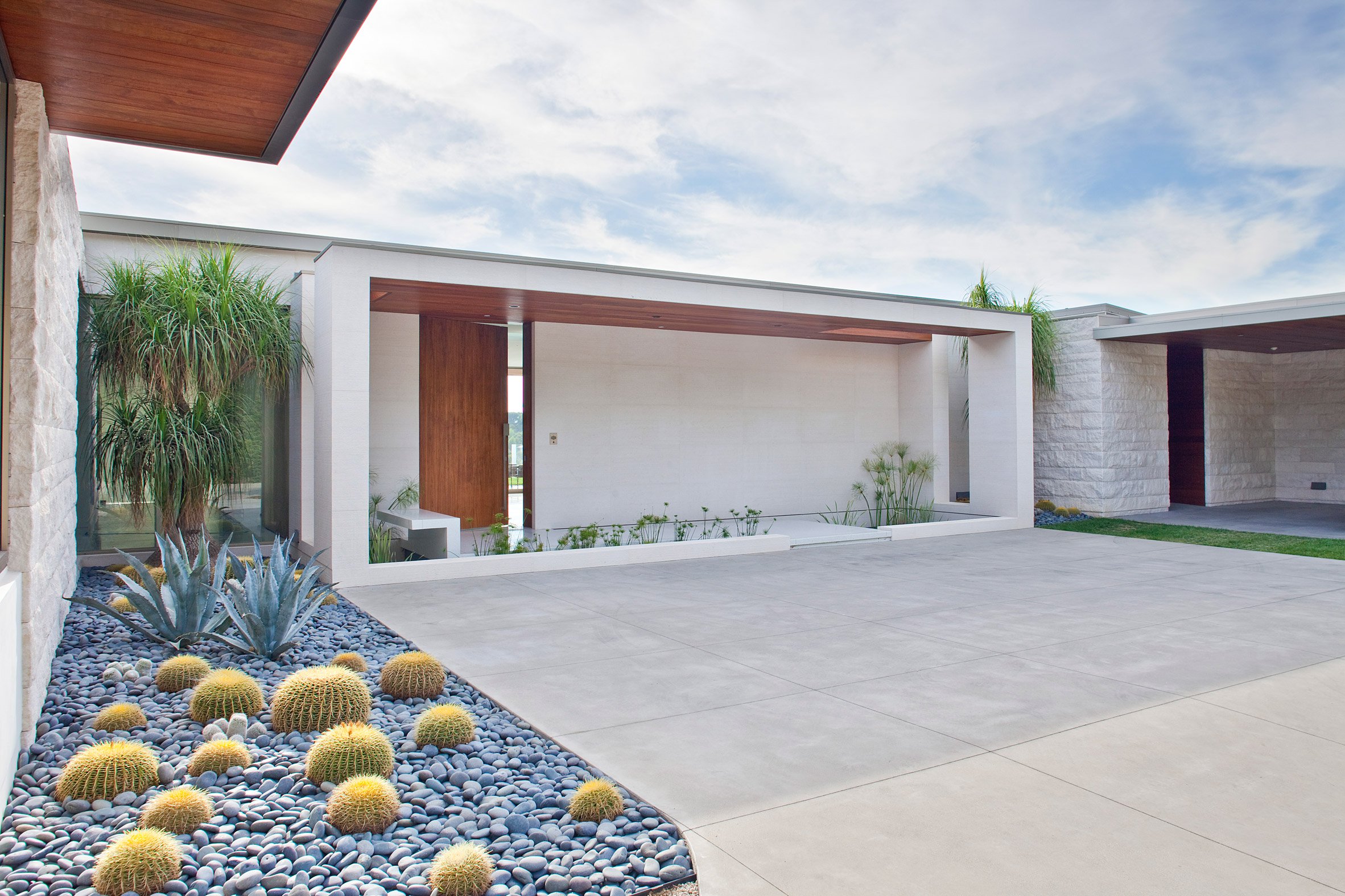 The house is painted white to avoid overheating, the courtyard is clad with white tiles, and there are cacti and succulents traditional for California