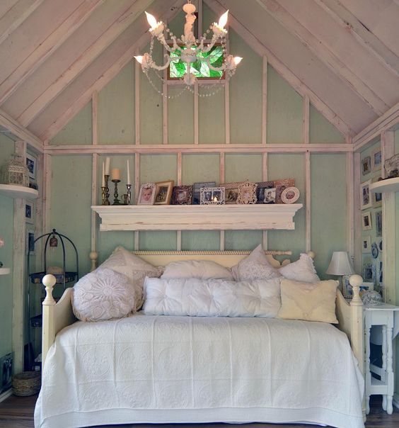 a simple shabby chic she shed with a daybed and some shelves for having a cozy rest