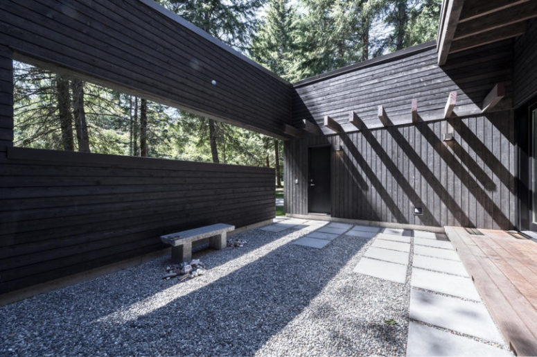 The courtyard is hardscaped with gravel, there are some tiles and a concrete bench, it's minimalist and cool