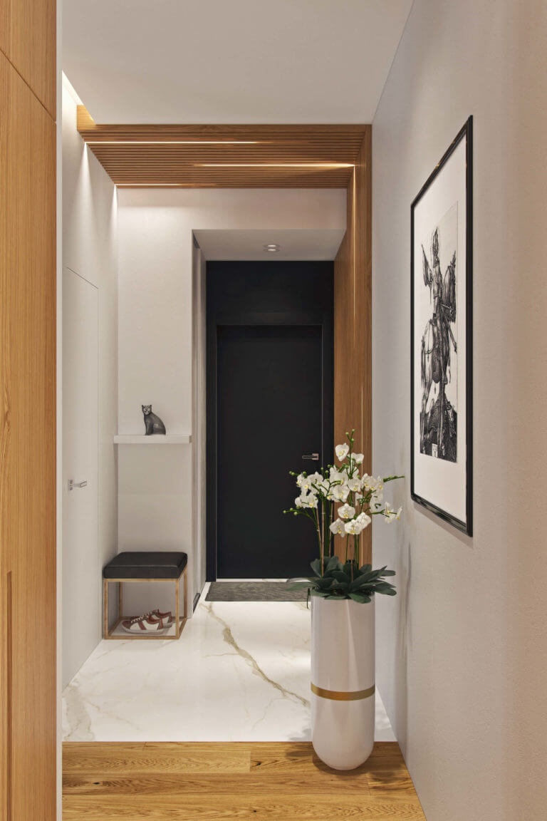 The floor in the entryway is marble, it looks fresh, refined and is durable, and a tall modern planter with beautiful flowers make the space refined