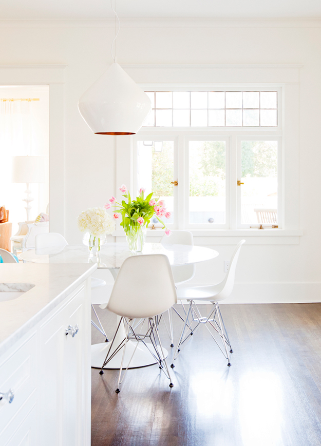 A small breakfast zone is more modern, with a large pendant lamp and modern chairs