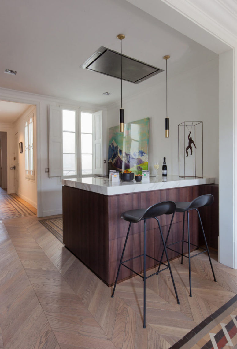 The kitchen island doubles as a breakfast zone or a home bar when needed