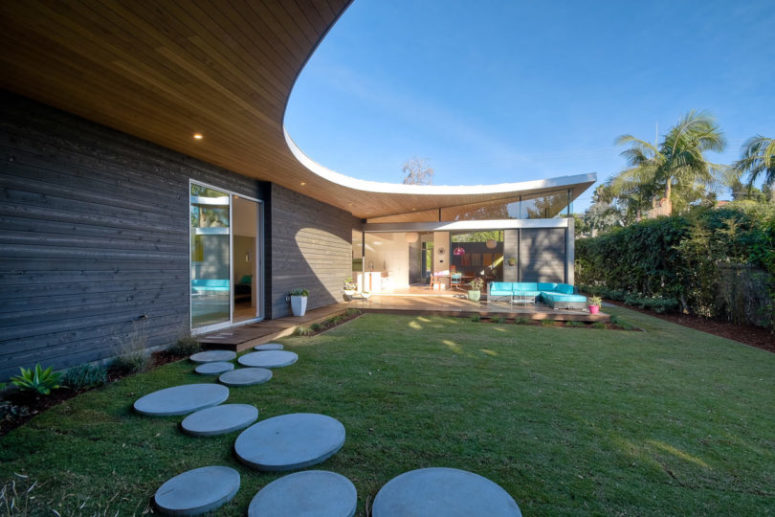 There's an outdoor lounge with a bold turquouse L-shaped sofa and some cool round stepping stones that add to the look