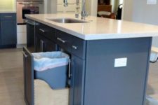 05 a pull out drawer with a trash can in the kitchen island