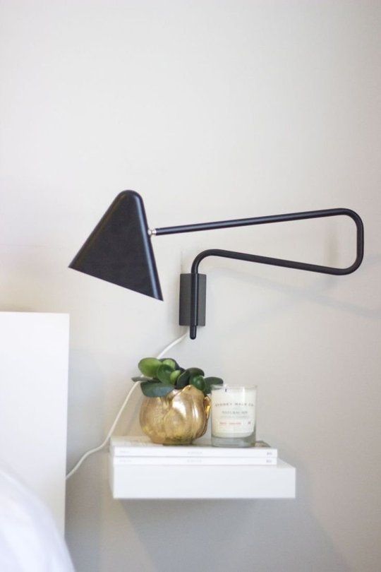 an ultra-minimalist floating white nightstand, which includes a tiny drawer