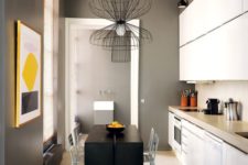 06 The kitchen is done in black, graphite grey and white, there’s a matte back table and kitchen island in one and white cabinets, and of course a bold artwork to enliven it all