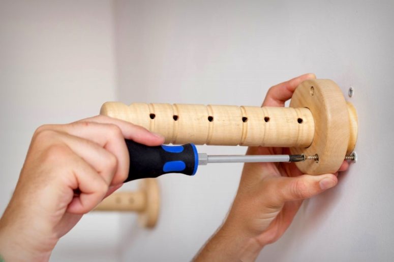 The wooden bases are attached to the walls to hold the tight ropes