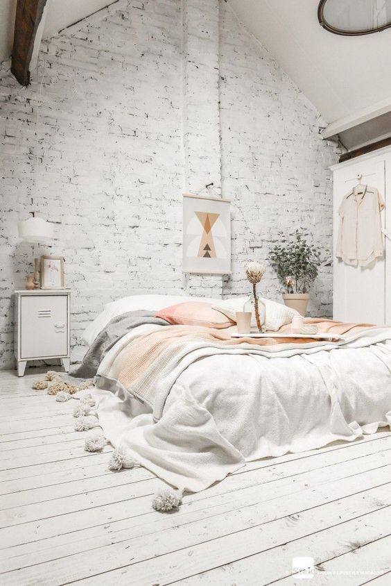 a whitewashed brick wall and wooden floors look very textural and catch an eye