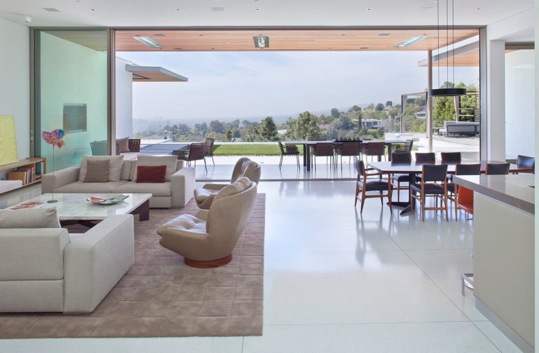 The living room, kitchen and dining room are united into one open space layout, and there's a separate outdoor dining zone