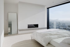 07 The master bedroom features a glazed wall with jaw-dropping views, a built-in fireplace and a large bed