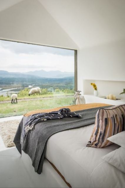 bedroom with an amazing view The master bedroom features a panoramic window with amazing and relaxing views including lake views