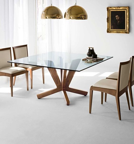 a square dining table with a glass tabletop and cool and stable wooden legs for a clean modern dining room