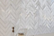 07 mother of pearl tiles clad in a chevron pattern for a refined bathroom