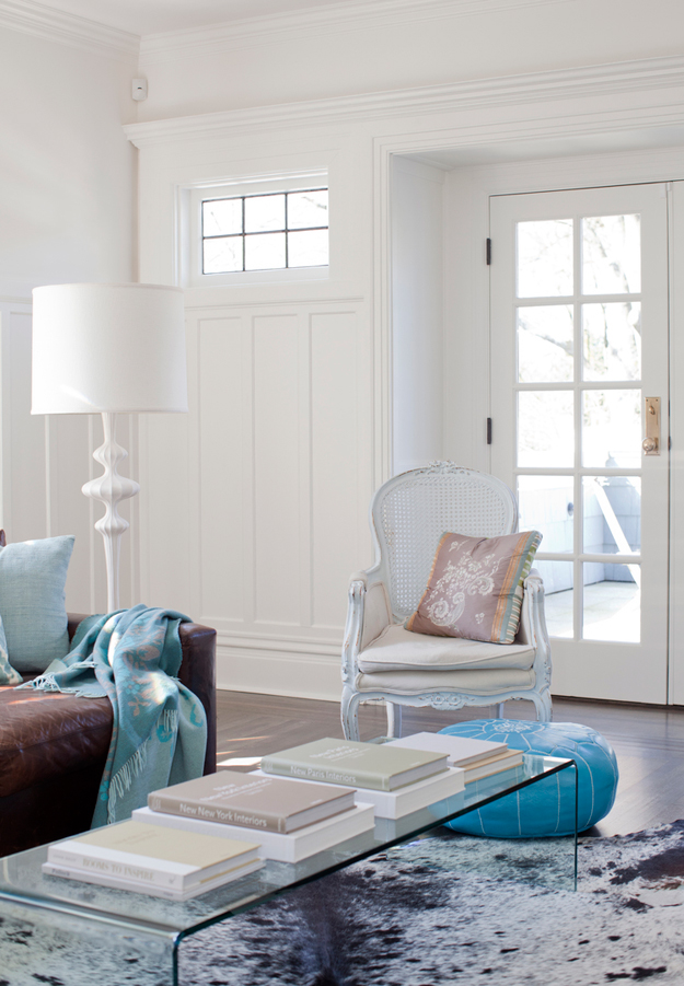 An animal print rug, a brown leather sofa and a mix of vintage and modern furniture make the room unusual