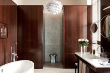 08 The bathroom is decorated with a refined feel yet looks very cozy due to the choice of dark stained wood for panels and furniture