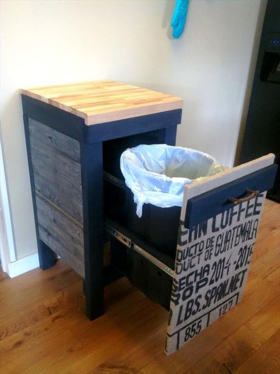 a rustic cabinet with a pull out trash can and an industrial facade