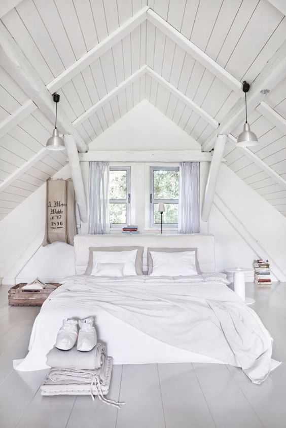 this bedroom is clad with whitewashed wood, and it looks cozier and warmer thanks to it