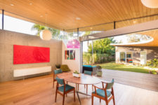 09 The dining space features mid-century modern furniture and bright artworks plus skylights