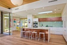 10 The kitchen is white and with stained wood touches for a cozy feel, I love the green hex tiles that ocver one of the walls