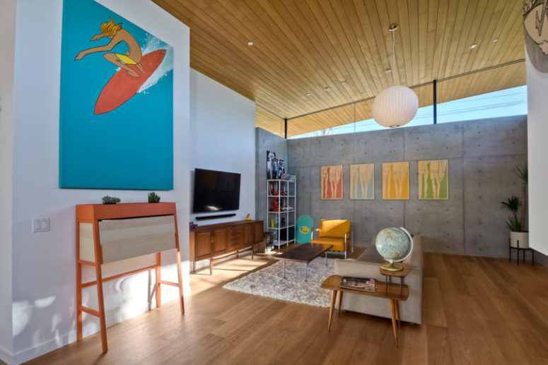 concrete walls for mid century interiors The walls are done of concrete, and the floors and ceilings are wooden, so bright artworks stand out in such spaces