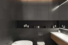12 The master bathroom is done in matte charcoal grey, with pebbles for a spa feel and a free-standing bathtub