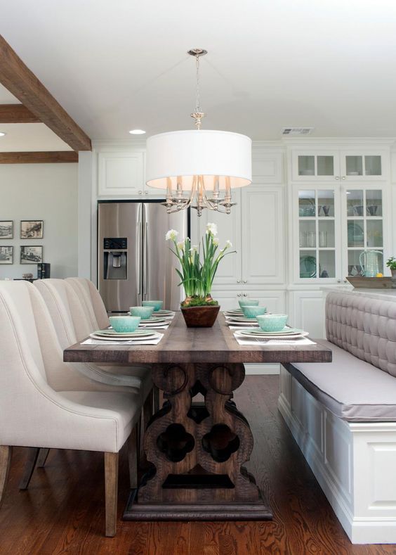 a modern dining space with upholstered chairs is made cozier with a dark stained trestle dining table