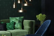 12 a moody space with a green velvet sofa and pillows and a navy velvet chair and brass lamps