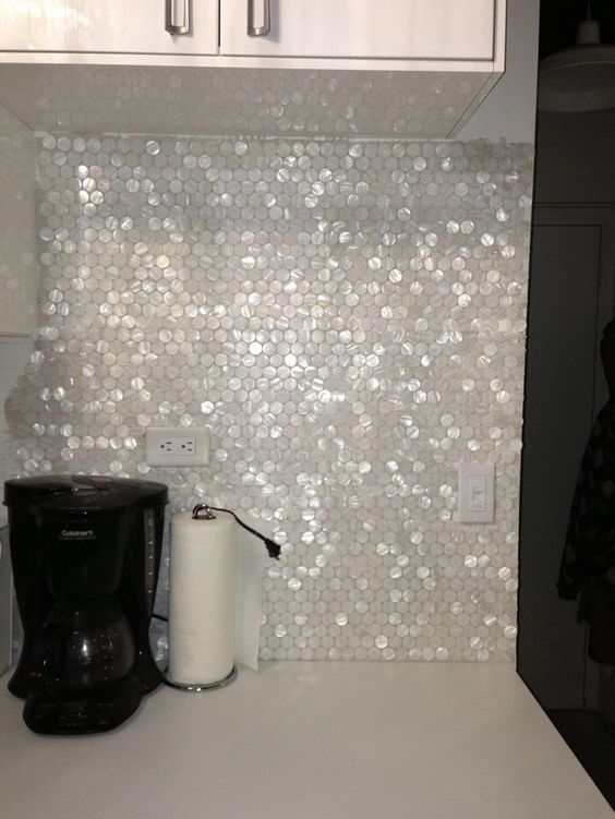 shiny mother of pearl hexagon tiles for a kitchen backsplash cheers up a white kitchen