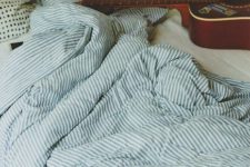 13 a blue striped bedding set and some accent botanical print pillows