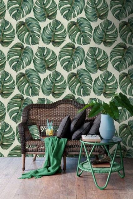 monstera leaf printed wallpaper echoes with a green coffee table and blanket