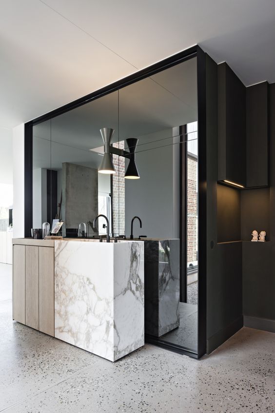 the sink zone is defined with a large wall mirror in a black frame