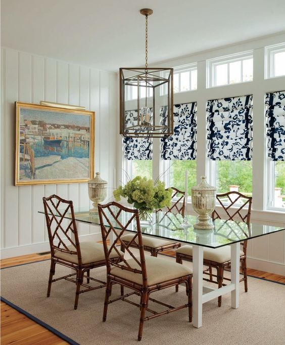 a rustic dining room is made more modern with a glass top dining table and white wooden legs