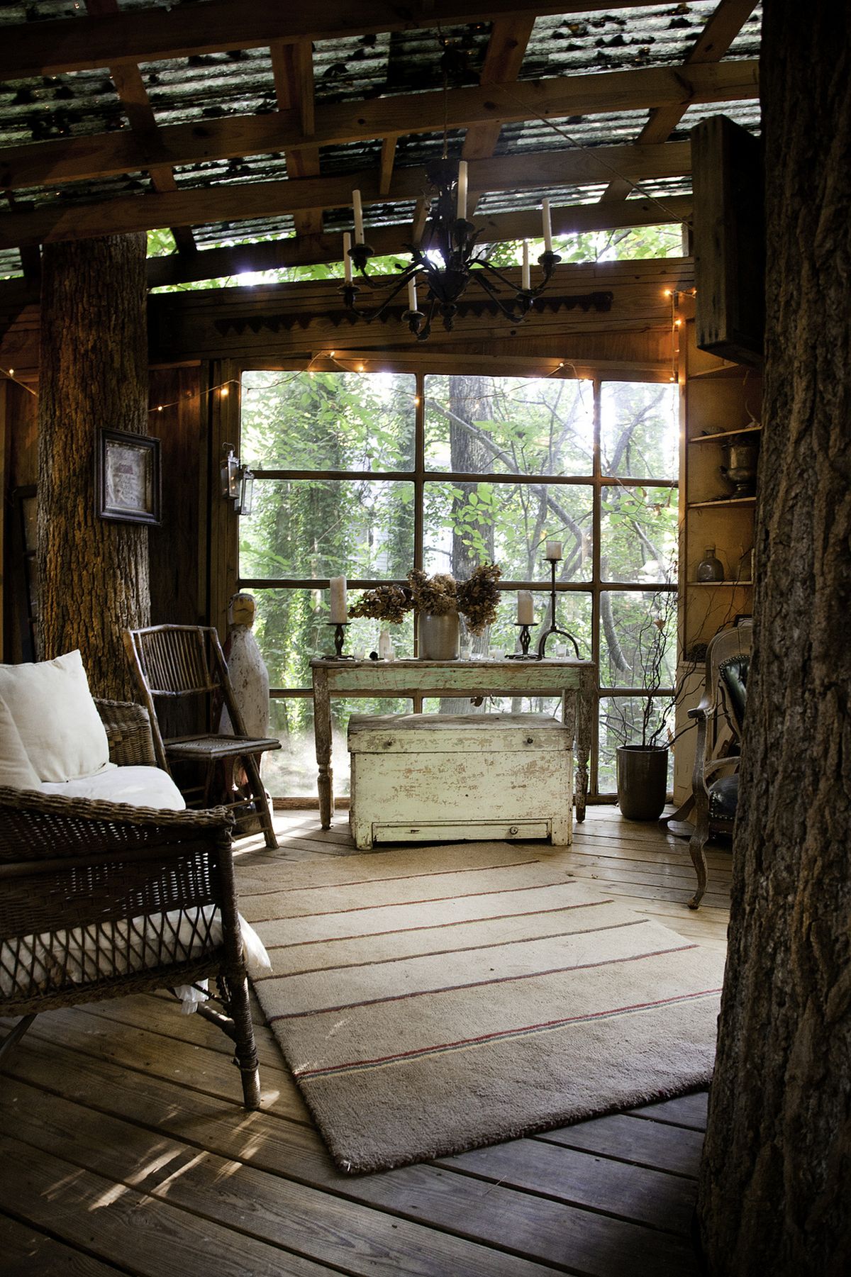 a treehouse she shed decorated as a shabby chic living room with wicker furniture