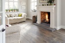 16 a white living room with grey and brown stained wooden floors, textural upholstery also adds to the space