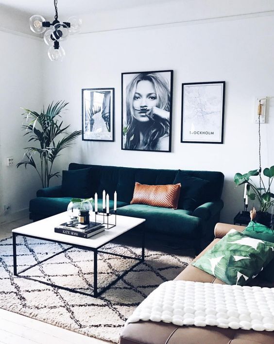 an emerald green velvet sofa echoes with greenery and leaf print pillows and makes this space lively