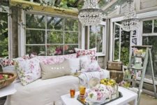 18 vintage-inspired glam she shed, a daybed with floral print pillows and glam chandeliers