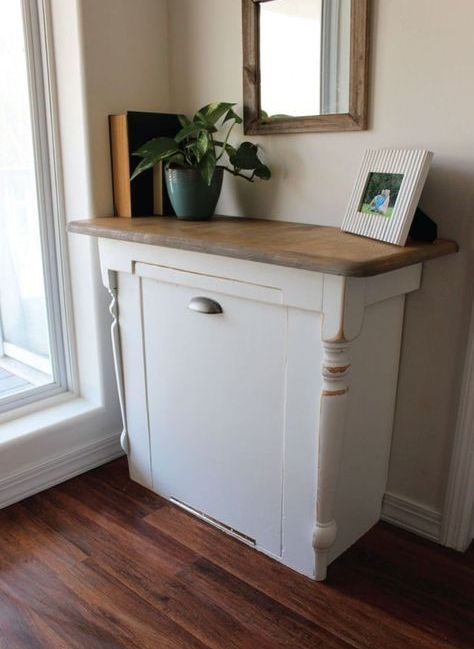 vintage-inspired white cabinet with a rustic top and a tilt out trash can