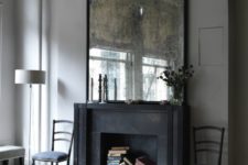 20 a living room is given chic and a vintage feel with an oversized antique mirror and a faux fireplace with books