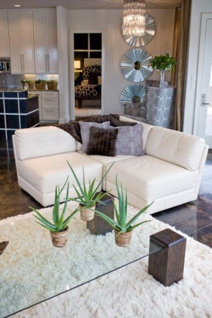 a modern glass coffee table with dark stained wooden legs for a cute rustic touch and coziness