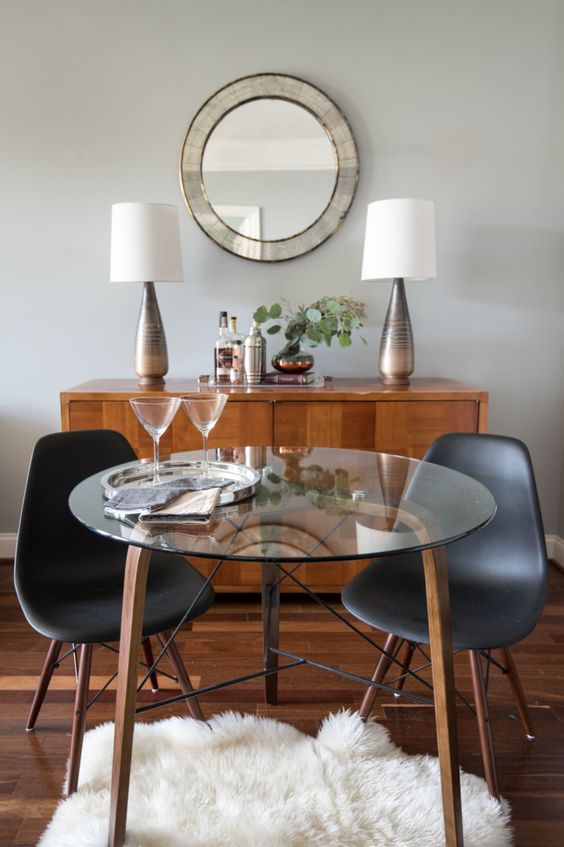 a small round table with wooden and metal legs and a glass tabletop for a cozy dining space or breakfast nook