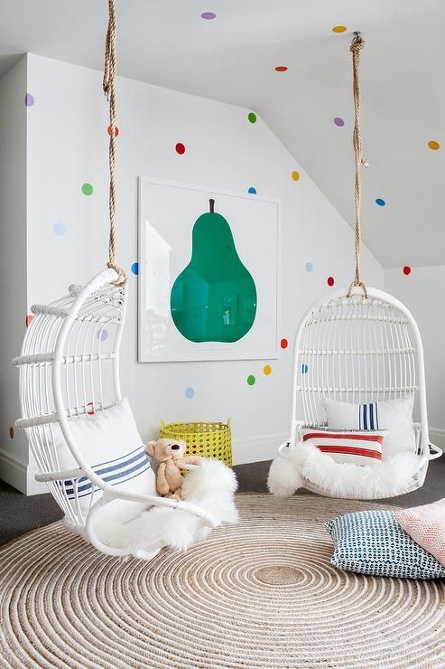 colorful polka dot wall decor, a bold fruit wall art and cool hanging chair make the nook super inviting