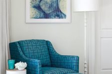 23 a blue armchair with a footrest and a geometric print looks chic and art deco inspired