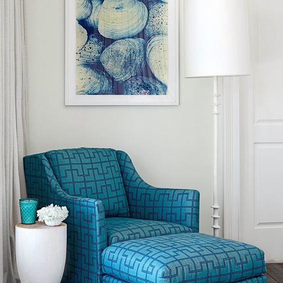 a blue armchair with a footrest and a geometric print looks chic and art deco inspired