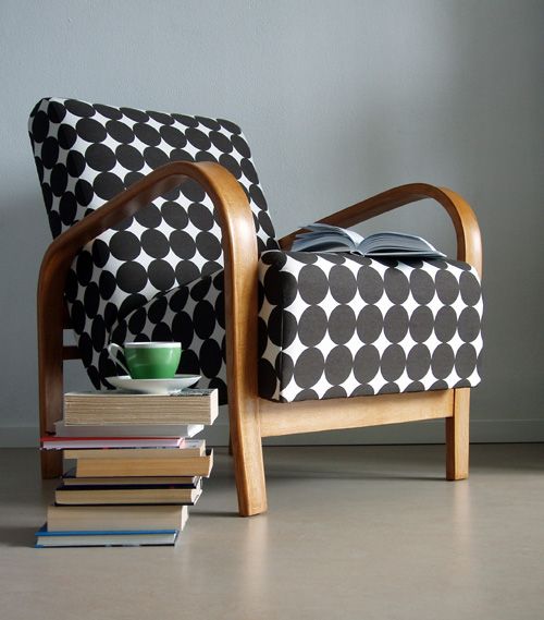 a black and white large circle upholstered chair with a wooden frame looks modern and chic