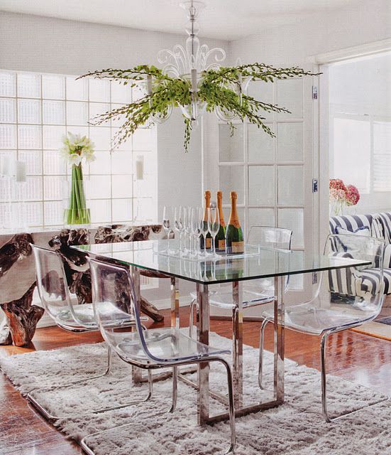 a dining table with metal legs and acrylic chairs on the same legs look modern, chic and ethereal