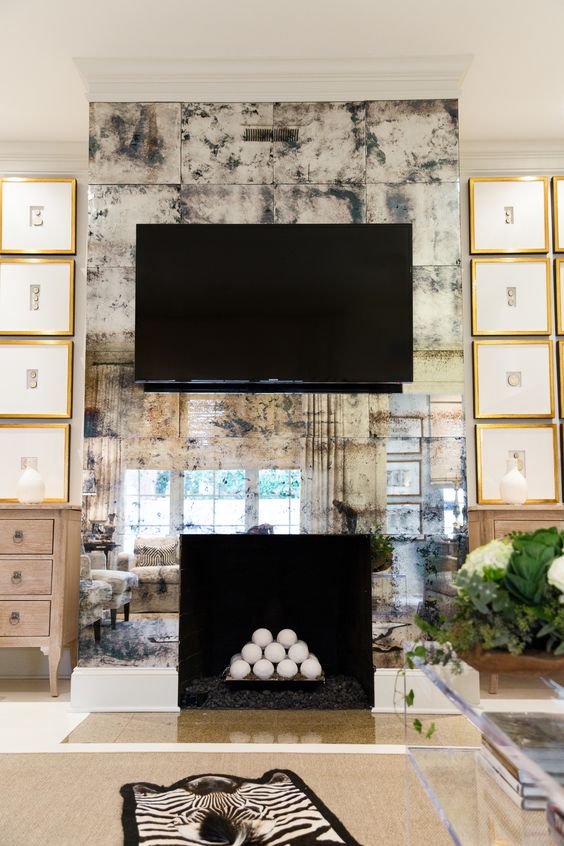 an antique mirrored wall accentuates the faux fireplace and the TV on it