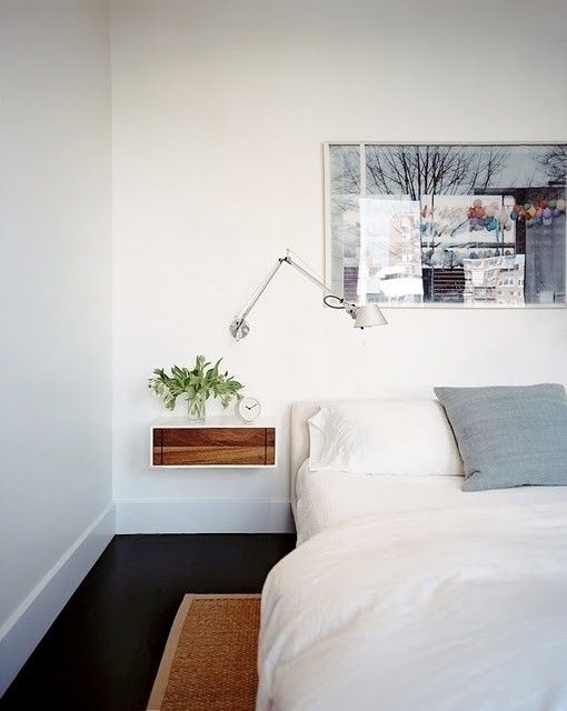 a modern tiny floating nightstand with a stained wood drawer for a chic look