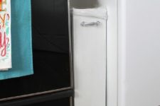 25 a small and stylish trash can is put between the fridge and the cooker and it’s not seen