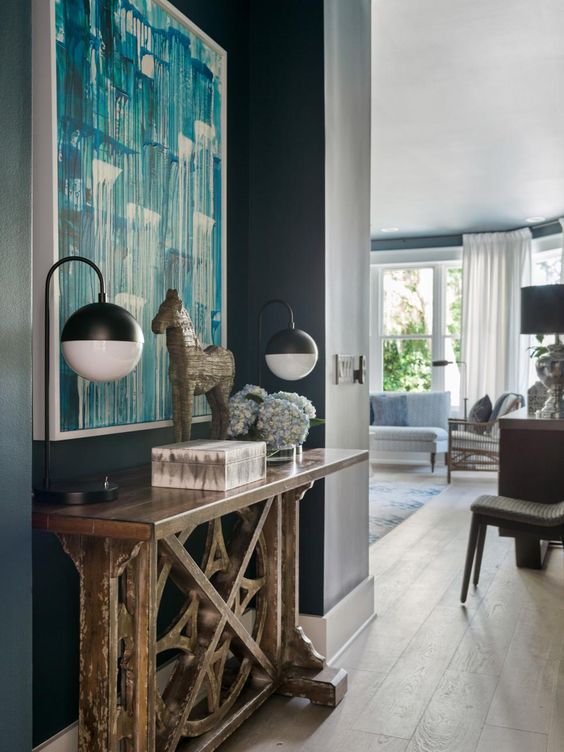 a small vintage rustic trestle table fits this refined modern space as a tiny console